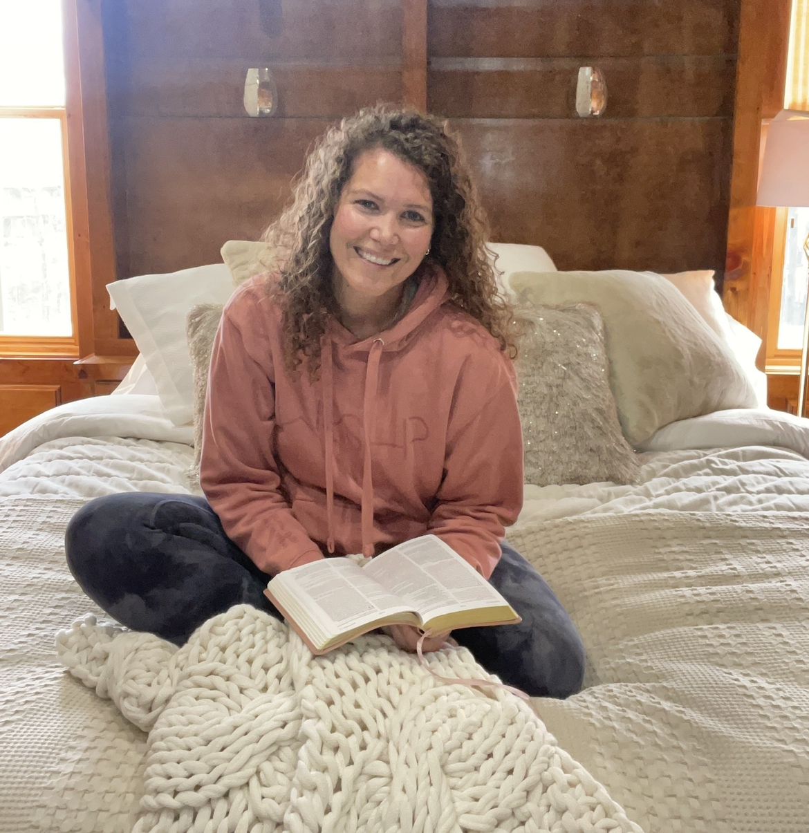 Kaela sitting on bed with Bible